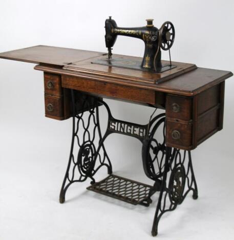 A free standing oak cased and metal framed sewing machine