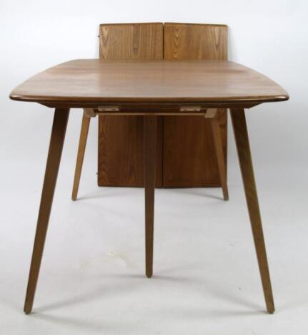 A mid 20thC Ercol light elm extending dining table