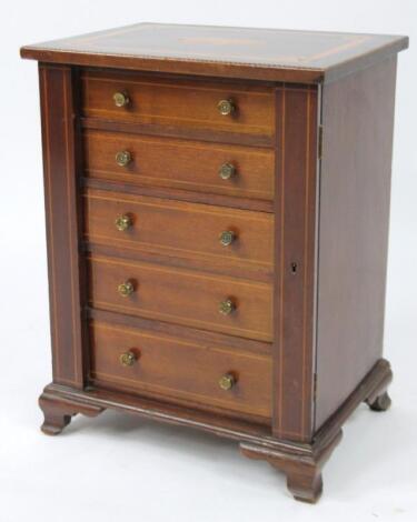 A 19thC Sheraton revival mahogany and boxwood table Wellington cabinet