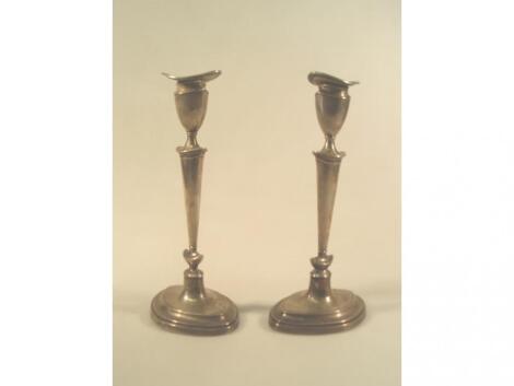 A pair of George V silver candlesticks of Adam design