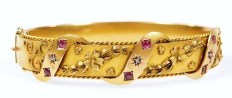 An Edwardian 9ct gold ruby and diamond bangle