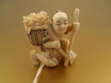 A 20thC Japanese ivory netsuke figure of a kneeling man with a basket of flowers