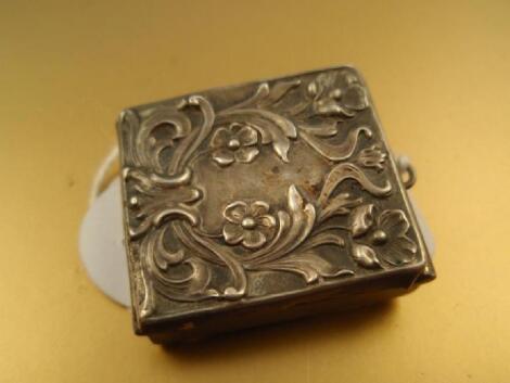 An early 20thC white metal stamp box with floral embossed cover and stamped