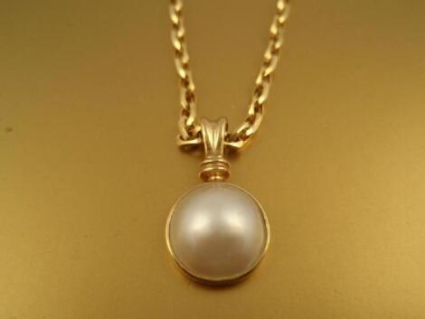 A half pearl bead pendant in 9ct gold with a fancy belcher chain