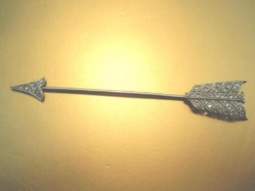 An arrow shaped stick pin with 8 cut diamonds set in flight and head all