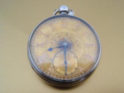 An open face silver pocket watch with gold damascened dial