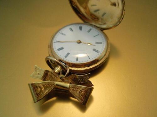 An 18ct gold cased hunter fob watch attached to a 9ct bow brooch<br