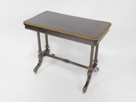 A Victorian ebonised and gilt brass fold over card table