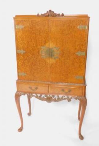 An early 20thC burr walnut cocktail cabinet