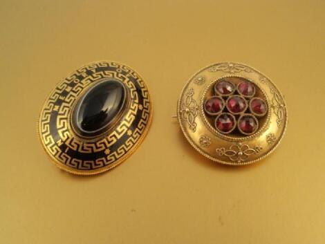 A Victorian circular memorial brooch set with seven faceted garnets and