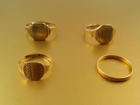 Three gentleman's signet rings in 9ct gold and a narrow 22ct gold wedding band