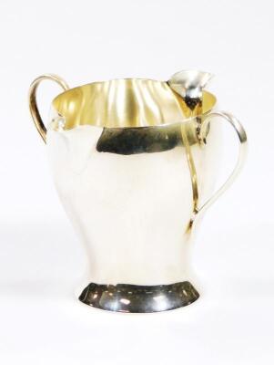 A Victorian Art Nouveau silver double lipped cream jug