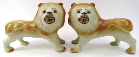 A pair of mid 19thC English pottery figures of standing lions