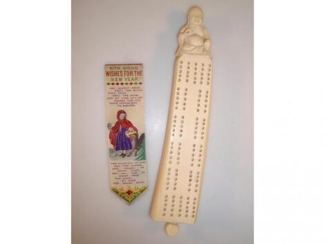 An ivory cribbage board surmounted by a figure of Hotei