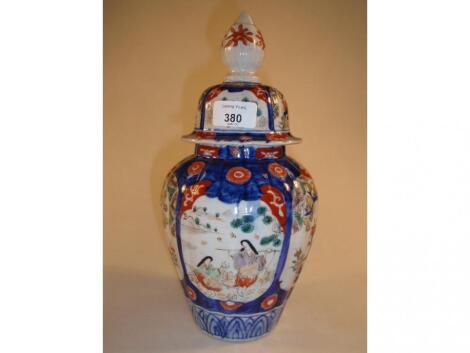 A Japanese Imari vase and cover of ovoid form painted with figural and flowering panels