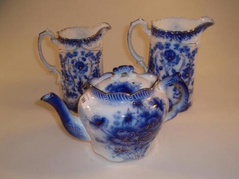 Two Victorian Staffordshire flow blue relief moulded graduated jugs and