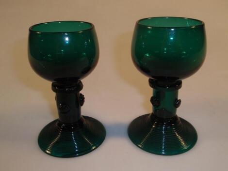 A pair of emerald green Romer small goblets with milled collar and applied