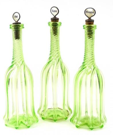 A set of three late Victorian green and clear glass twist decanters