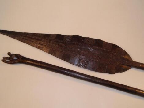 A pair of tribal carved hard wood paddle spears