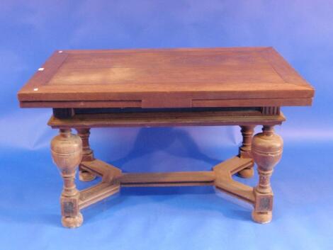 A continental oak drawer leaf table raised on four bulbous turned legs