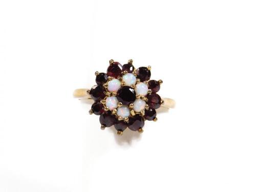 An early 20thC ladies garnet and opal dress ring