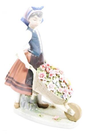 A 20thC Lladro figure of a girl pushing a wheelbarrow