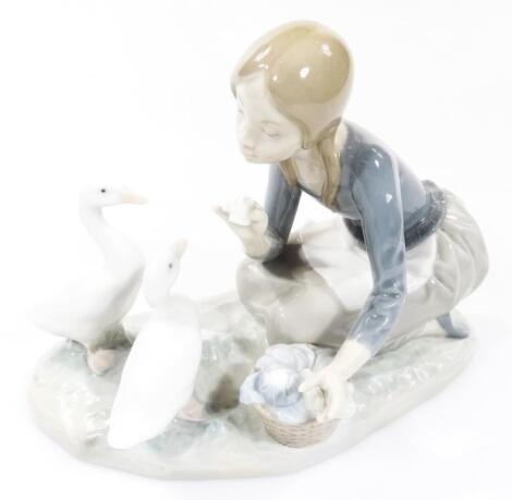 A 20thC Lladro figure of a girl feeding geese