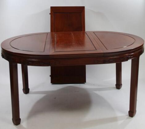 A modern Chinese cherry wood oval extending dining table