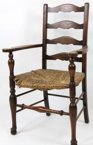 A 20thC ash and elm ladder backed carver chair