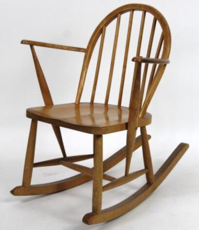 A mid 20thC child's stick back lightwood rocking chair