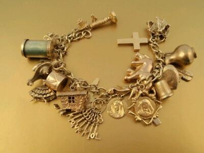 A 9ct gold curb link bracelet with padlock clasp and twenty five attached charms