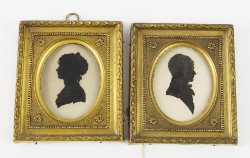 A pair of oval silhouette portraits of a gentleman and a lady