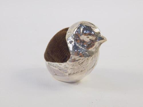 A silver pin cushion modelled as a chick