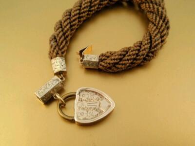 A Victorian thick woven hair bracelet with yellow metal locket and fittings