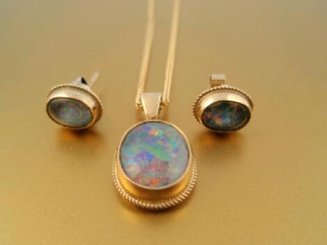 An oval cabachon opal pendant and matching earrings