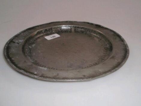 A Hugh Wallis planished pewter plate 27cm dia