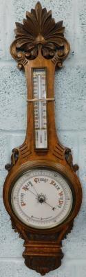 An early 20thC carved aneroid barometer