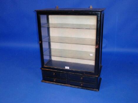 A Victorian ebonised wall cabinet with glazed upper part and three-drawer shelf base