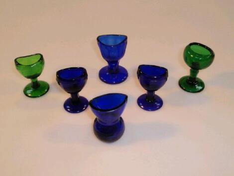 Four Victorian "Bristol" blue glass eye baths together with two green examples