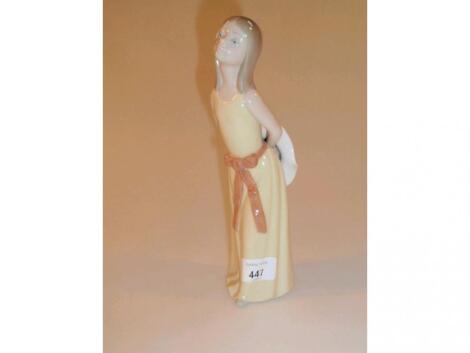 A Lladro figure of a young girl wearing a yellow dress