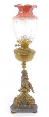 A cast metal and brass oil lamp