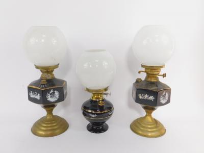 A pair of brass and ceramic oil lamps