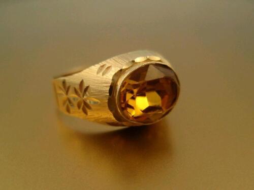 A dress ring set with a yellow stone to lightweight yellow metal shank