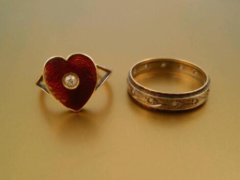 A heart shaped signet ring with red enamelled head set with a small diamonds