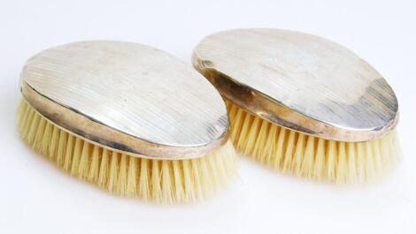 A pair of George V silver backed clothes brushes
