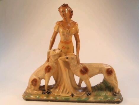 A plaster Art Deco group of a young lady with two Borzoi hounds