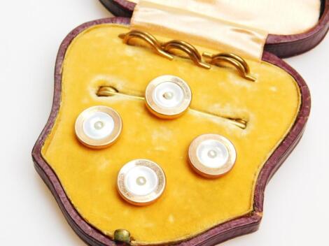 An early 20thC 9ct gold and mother of pearl finish shirt stud set