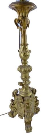 A 19thC carved gilt wood baroque table lamp on three feet.