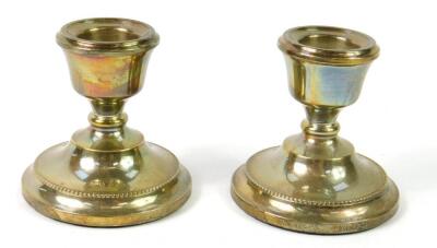 A pair of loaded silver squat candlesticks