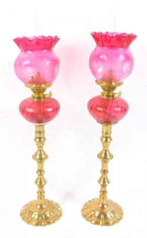 A pair of French Gaudard brass and cranberry glass oil lamps